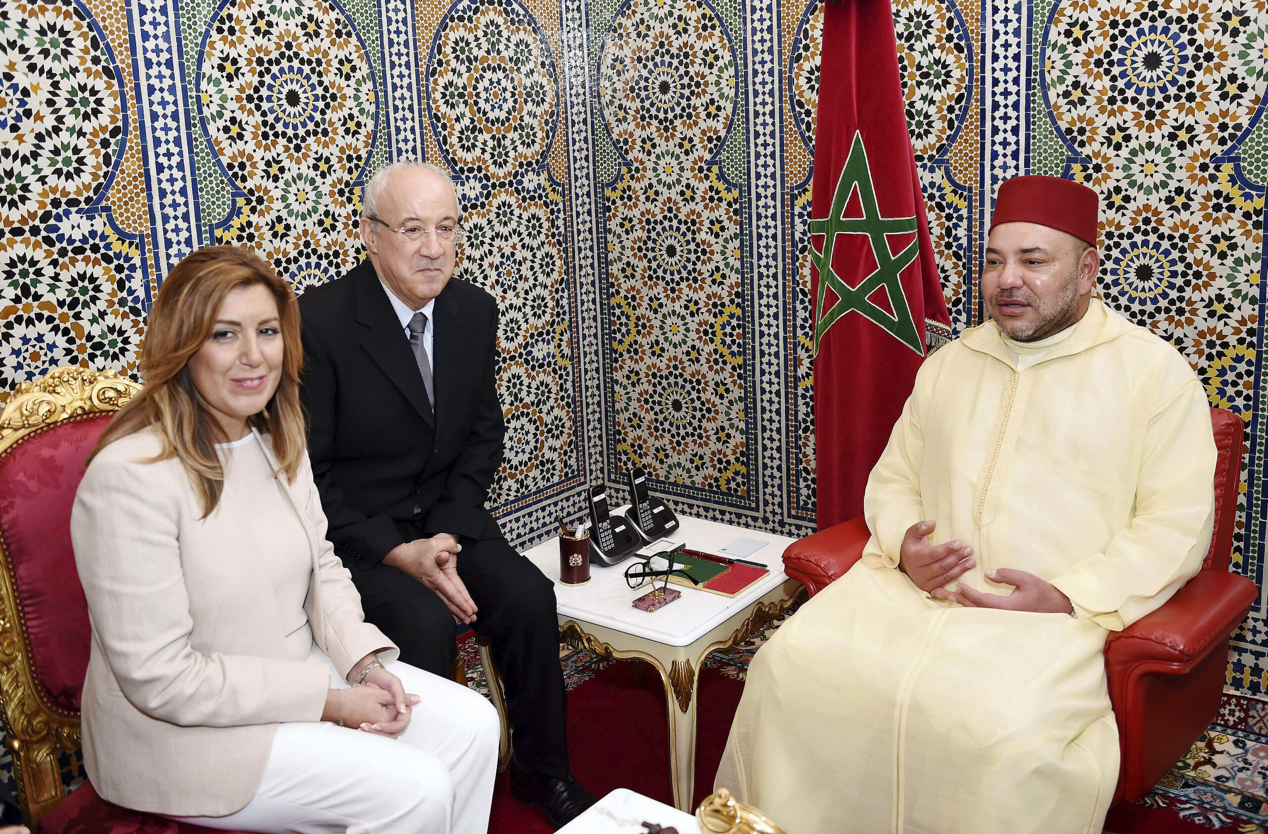 Mohamed VI en una reunión oficial junto a la bandera de Marruecos